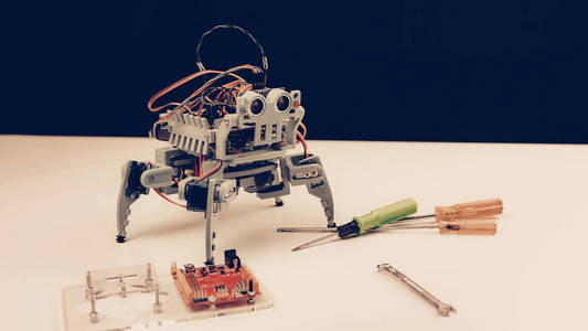 桌子上有工具的灰色小机器人. 现代技术. 机器人工程概念.