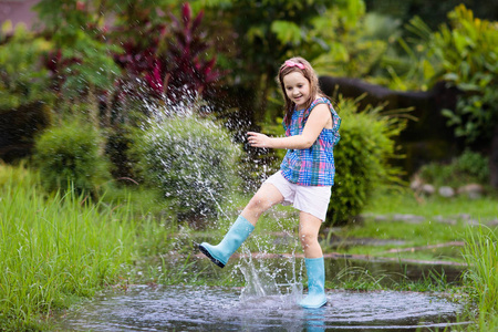 孩子们在下雨的秋天天气里玩得很开心.在热带风暴中奔照片
