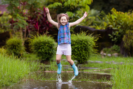 孩子们在下雨的秋天天气里玩得很开心.在热带风暴中奔照片