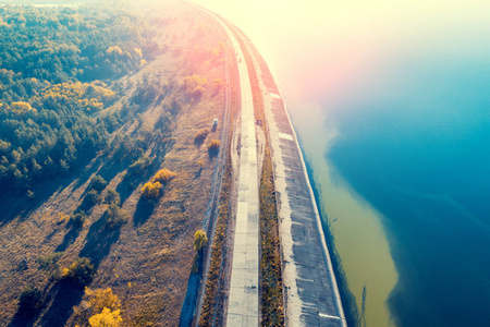 日落时分沿河堤坝上的道路照片