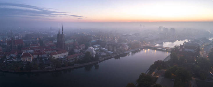 黎明时分，城市上空弥漫着烟雾的鸟瞰，远处的建筑物被雾和烟雾笼罩着波兰。