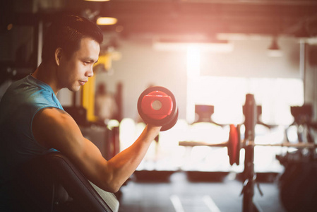人手握哑铃在健身房锻炼。 健身肌肉身体与一套黑色重量在健身房背景。 运动和健康的生活方式概念。