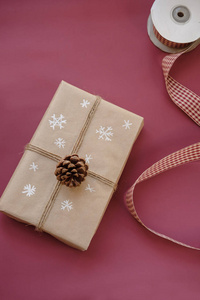 勃艮第玛萨拉颜色背景上的圣诞礼品盒。 带有手工装饰的圣诞礼物。 快关门。 复制空间