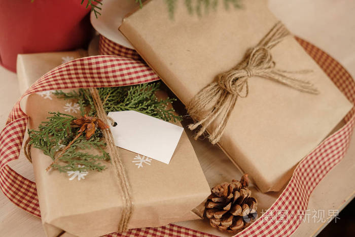 老式圣诞礼品盒上的空白礼品标签。 带有手工装饰的圣诞礼物。 快关门。 模型。 复制空间。