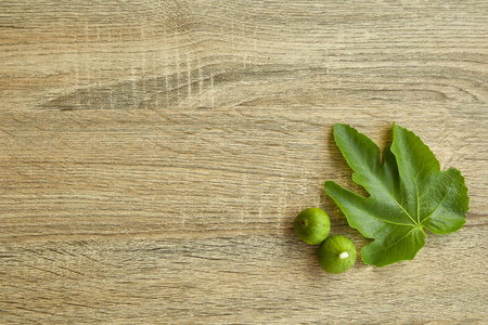 上面的新鲜水果无花果，叶子在木制背景上。 设计自然阳光的空间