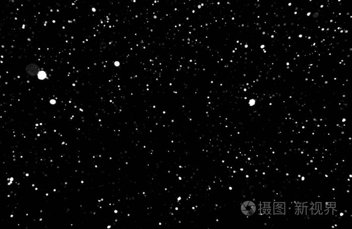 暴风雪的质地黑色背景下的灯光天空中飞舞的雪花