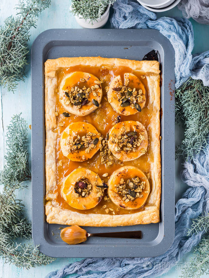 苹果派在烤盘上与焦糖和坚果