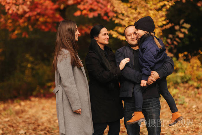 幸福的一家人在森林里散步爸爸妈妈和两个妹妹在公园度假色彩斑斓的