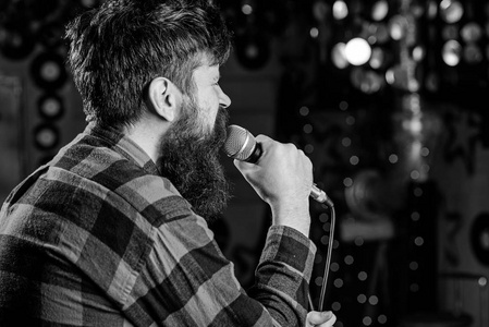 饶舌歌手衬衫男子在格子衬衫举行麦克风, 唱歌, 卡拉 ok 俱乐部的背景