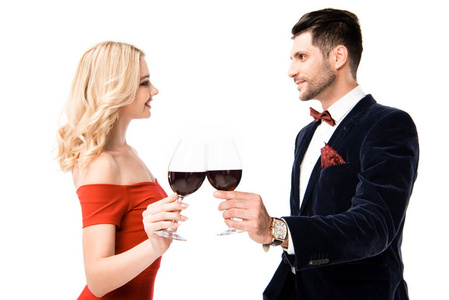 幸福的微笑的夫妇，一对戴着红葡萄酒的夫妇，在白色的玻璃上碰杯
