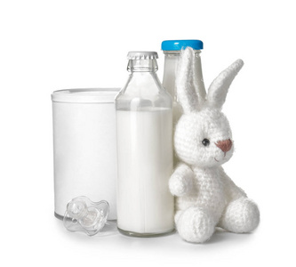带婴儿玩具的牛奶瓶和白色背景的奶嘴
