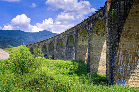 铁路高架桥老桥的背景是山脉。 乌克兰喀尔巴阡山脉