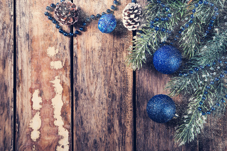圣诞背景与复制空间蓝色球与花环和松果在深色木制背景，老式风格