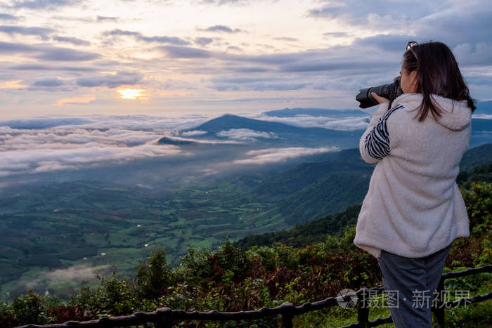 女游客正在使用dslr相机拍摄自然景观,冬季日出时太阳雾山,在泰国卢埃