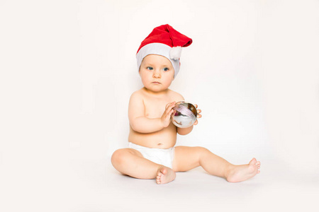s holidays. Baby in a Christmas costume holding silver Christmas