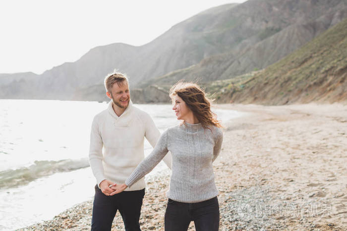 恋爱中的男人和女人一起在海边嬉戏在海滩边奔跑笑着亲吻拥抱