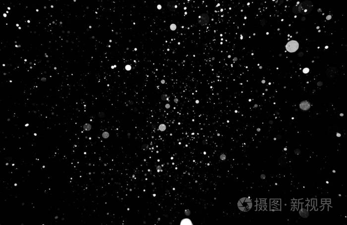 暴风雪的质地黑色背景下的灯光天空中飞舞的雪花