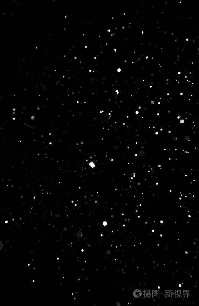 暴风雪的质地. 黑色背景下的灯光,天空中飞舞的雪花