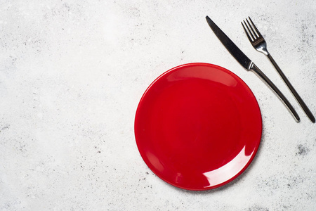 轻质石桌上的红色盘子和餐具