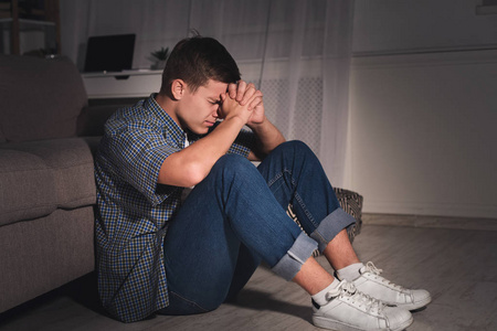 伤心十几岁的男孩绝望的十几岁的男孩在黑暗的房间里在家里照片