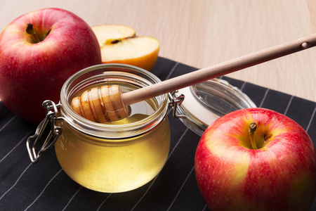 新鲜蜂蜜和苹果放在木桌上