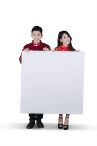 中国夫妇身穿旗袍，手持空白白板，在白色背景上隔离