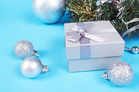 美丽的银礼品盒的组成与可爱的丝质蝴蝶结和闪亮的圣诞鲍附近松树枝。 新年和圣诞节庆祝概念。