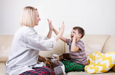 快乐的母子坐在家里玩游戏, 一起拍手照片