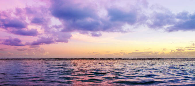 热带海洋和粉红色的天空背景。旅行背景