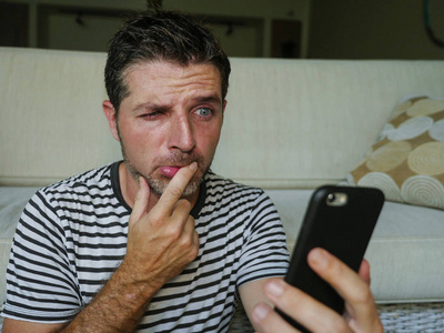 愚蠢的脸生活方式肖像年轻困惑和压力过大的滑稽男人拿着手机看起来有