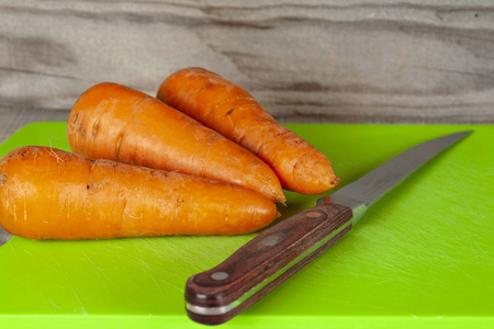 胡萝卜和菜刀躺在木板上