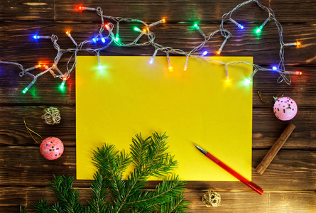 圣诞树树枝花环在木板的背景上锥出一张干净的床单和一支钢笔。 卡片和问候的颜色模板。 圣诞快乐，新年快乐，2019年