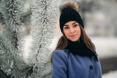 美丽的冬天的白雪皑皑的冬天的景色的年轻女子的画像