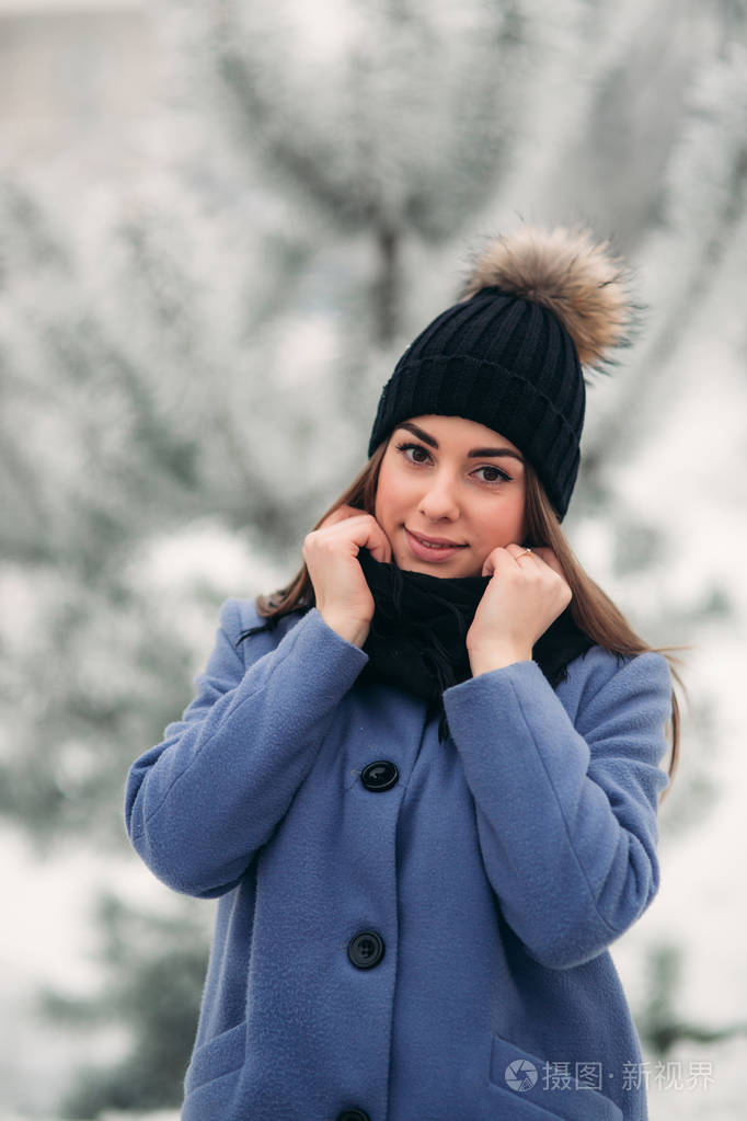 美丽的冬天的白雪皑皑的冬天的景色的年轻女子的画像照片-正版商用