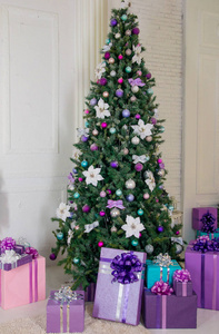 圣诞树下的圣诞节和新年礼物。 明亮的冬季绿色圣诞树，装饰着圣诞玩具。