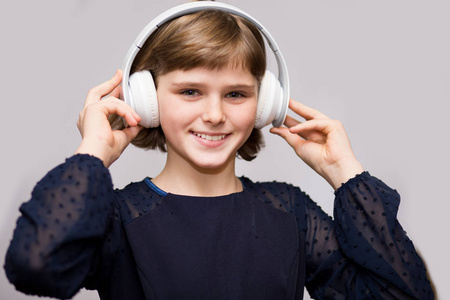 快乐微笑的孩子喜欢在白色背景下用耳机听音乐