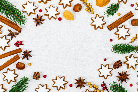 圣诞背景与明星姜饼饼干和节日装饰白色木制背景与空间文本。