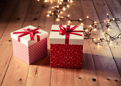 木制地板上的红色礼品盒和圣诞灯