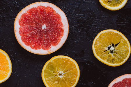 美味的各种类型的新鲜柑橘水果在黑暗的背景。 健康的饮食。