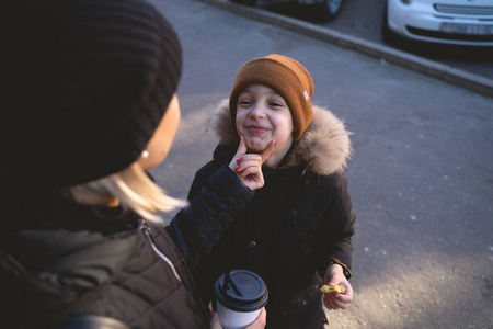年轻的母亲和儿子在冬天吃街头食物, 玩得开心 