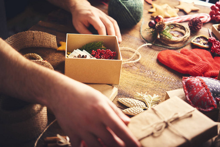 s hands holding open gift box a preparing christmas gifts. Chris