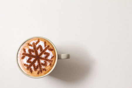 圣诞节期间，在牛奶泡沫中加入肉桂雪花图案的卡布奇诺咖啡，圣诞咖啡