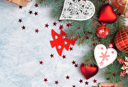 圣诞树树枝上覆盖着雪和石头背景上的宝布尔装饰。 圣诞背景你的贺卡与文字空间