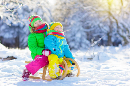 孩子们在雪地里户外玩耍. 孩子们在冬天的雪地公园里雪橇.