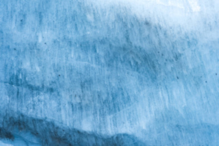 一个有着数百年历史的冰川的近距离模糊的墙壁, 有条纹和气泡的结构。冰蓝色光纹理