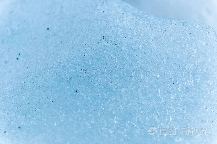 冰川碎片表面的特写镜头其结构是条状和气泡夹杂着沙子和岩石冰蓝色的