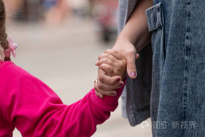一个女人紧紧地抓住一个孩子的手