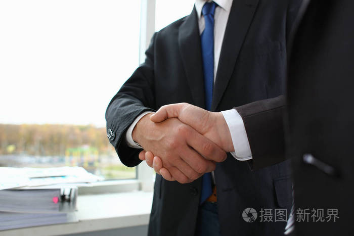 穿着西装的男人握手作为办公室你好