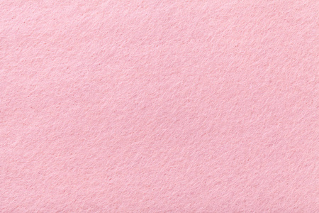 浅粉色哑光背景的绒面织物特写。 天鹅绒质地的无缝玫瑰毛毡。