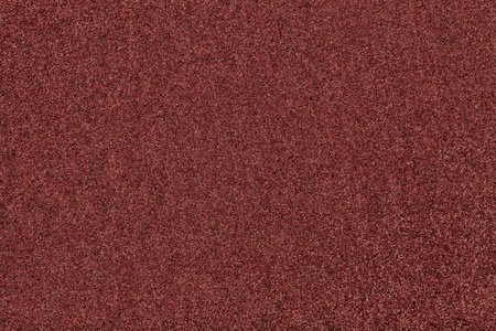 黑褐色哑光背景的绒面织物特写. 无缝红色毛毡的天鹅绒质地.照片